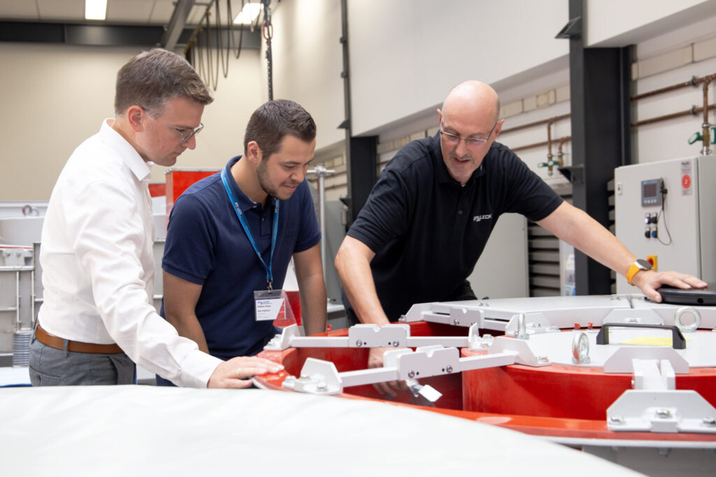 Zwei Mitarbeiter und ein Besucher von Spaleck Oberflächentechnik in der Fertigung beim Technikum